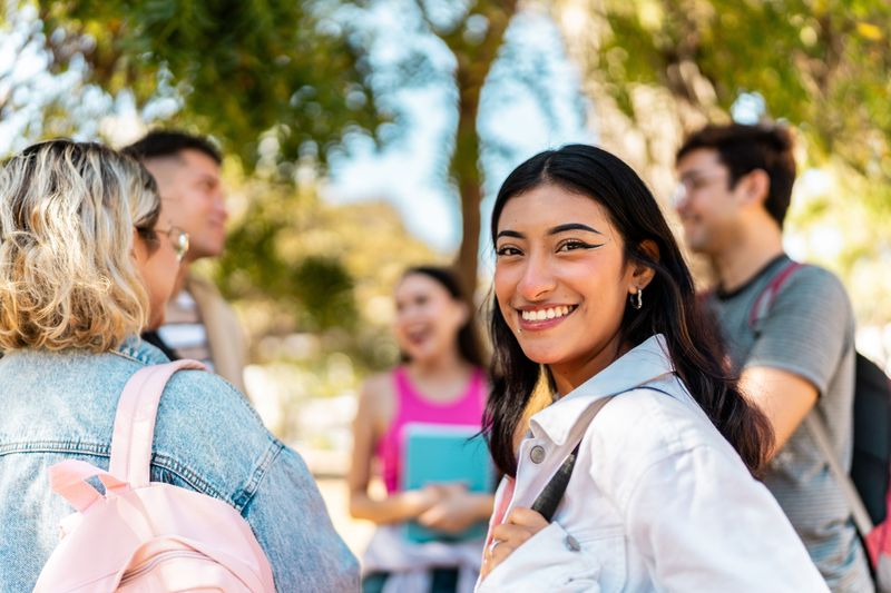 Smiling students outside with backpacks