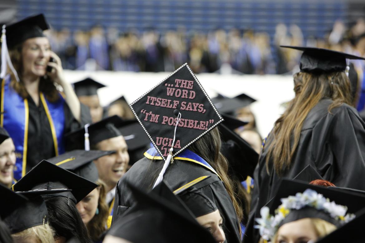 Graduating student with a graduation cap that reads "the word itself says, 'I'm possible!' UCLA '15"